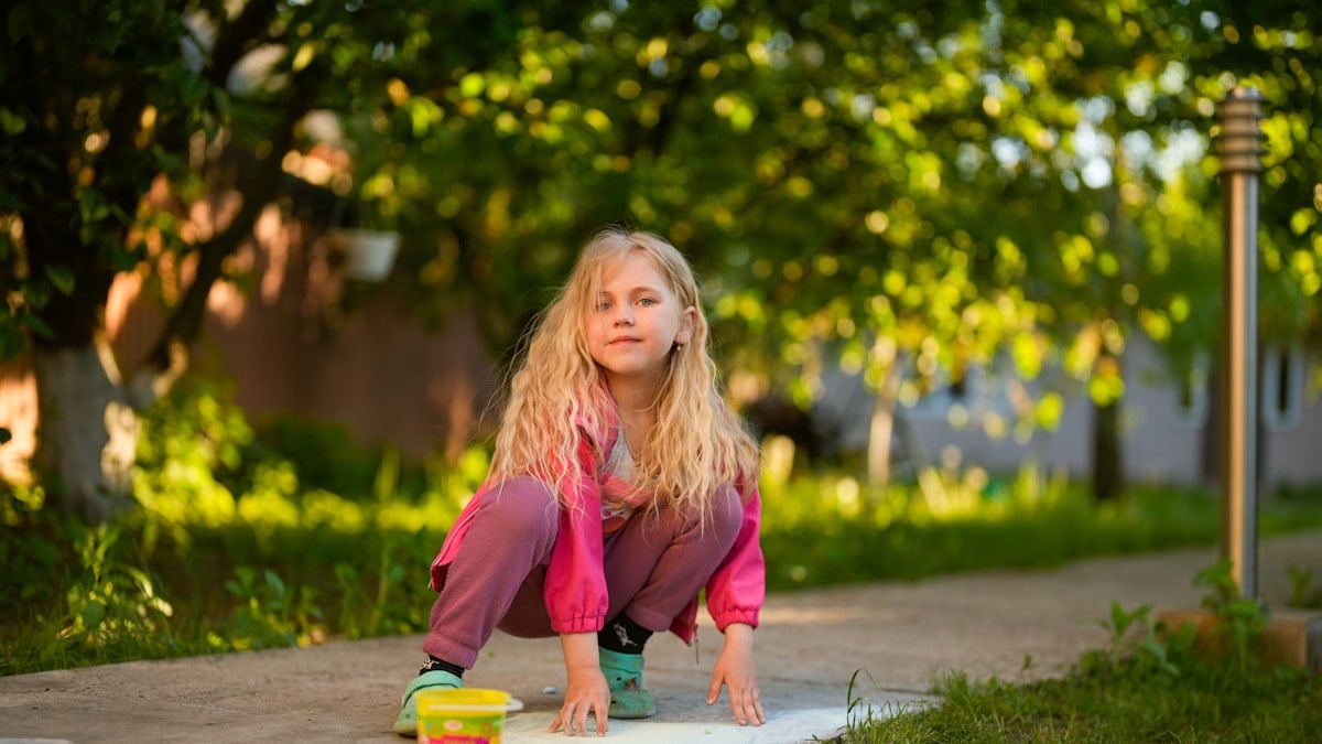 A little girl playing with a toy truck