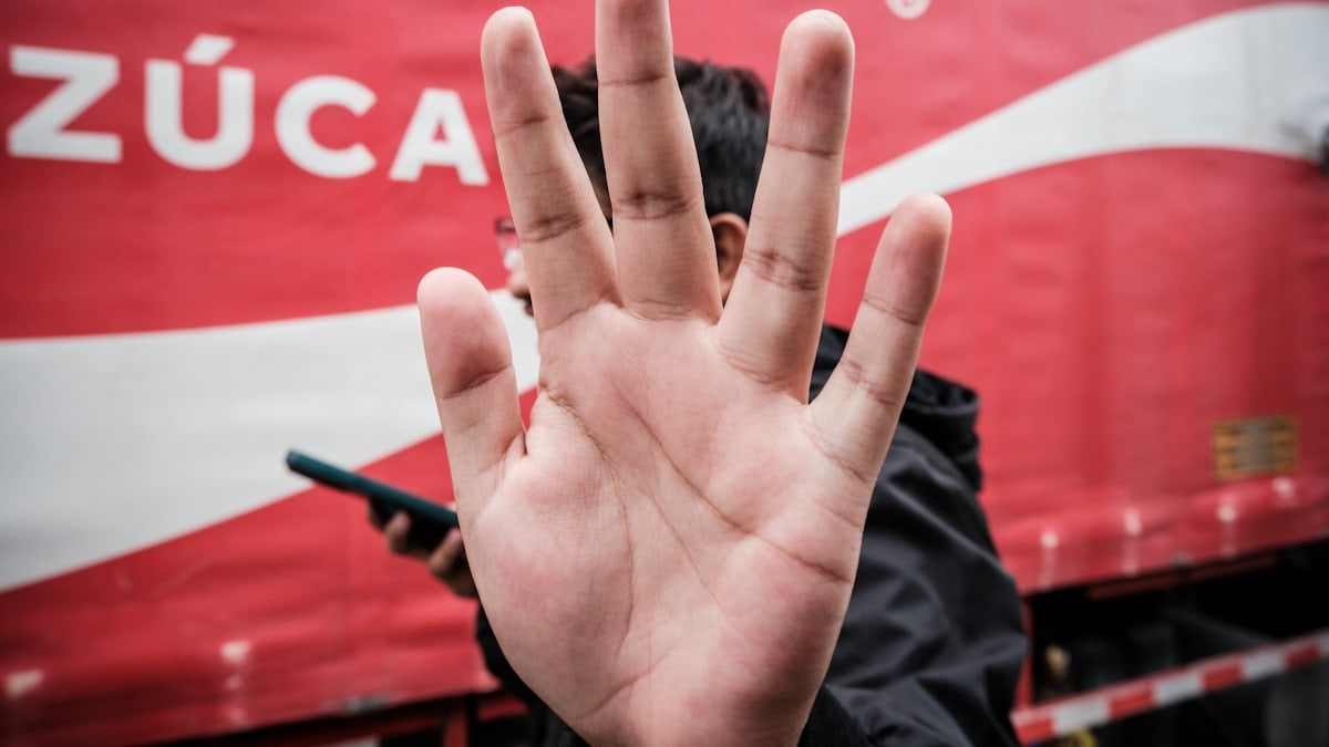 a person with their hand up in front of a coca - cola truck